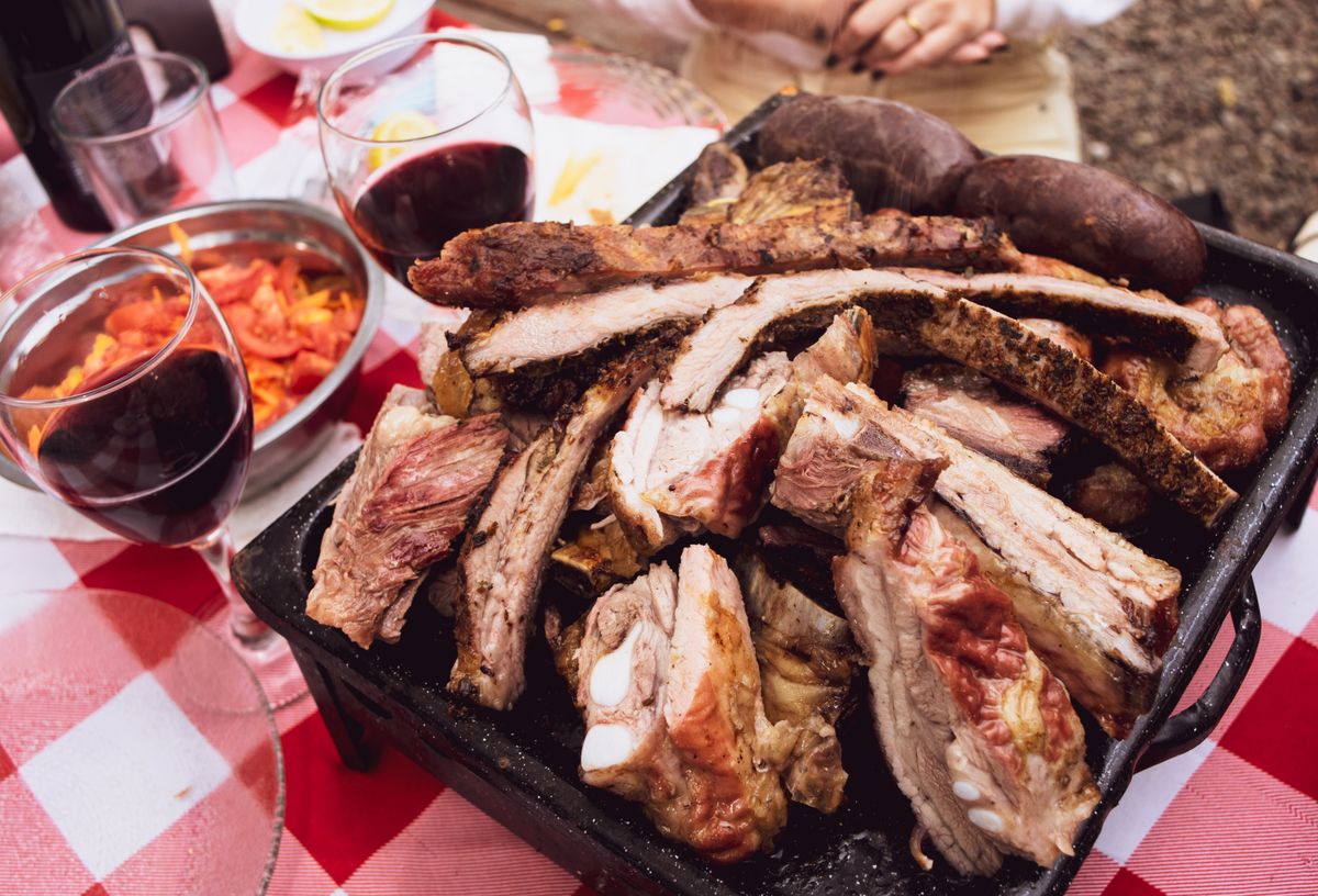 An Argentine asado laid out with a bottle of red wine